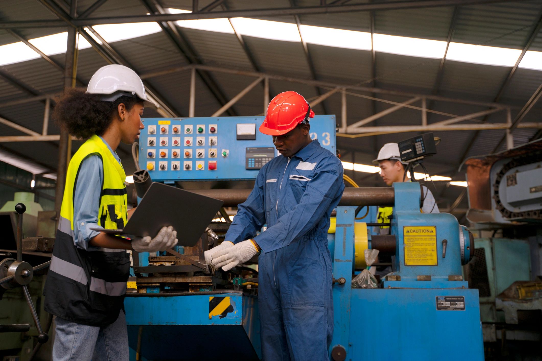 Industrial workers reviewing equipment inside a factory